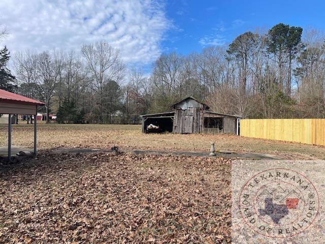 view of yard with a carport and an outbuilding