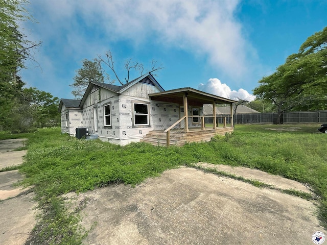 view of front of property featuring fence, a porch, and central AC unit