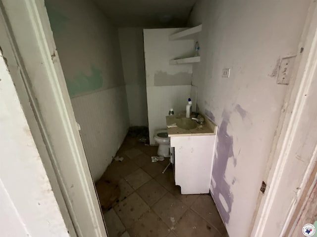 bathroom featuring tile patterned flooring, toilet, and vanity