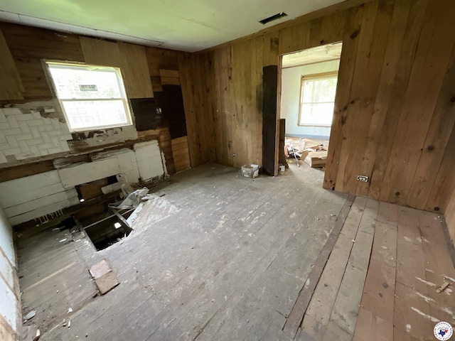 interior space with wooden walls and light wood finished floors