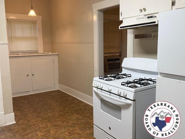 2308 Laurel St, Texarkana, AR 71854 - kitchen with white appliances, extractor fan, white cabinets, hanging light fixtures, and light countertops