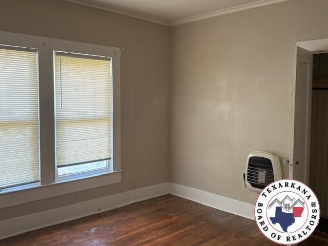 2308 Laurel St, Texarkana, AR 71854 - spare room featuring dark wood-type flooring and ornamental molding