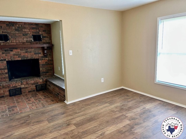 704 Florence St, Atlanta, TX 75551 - unfurnished living room with wood finished floors, baseboards, and a fireplace