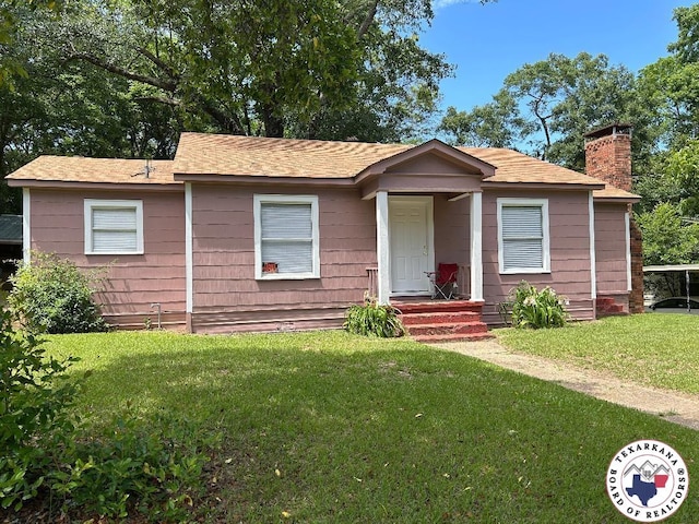 704 Florence St, Atlanta, TX 75551 - view of front of property featuring a front lawn, a chimney, and roof with shingles