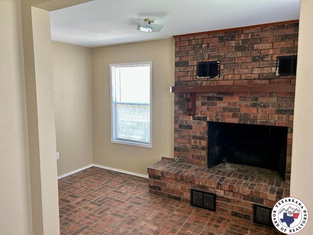 704 Florence St, Atlanta, TX 75551 - unfurnished living room with baseboards, brick patterned floors, and a brick fireplace