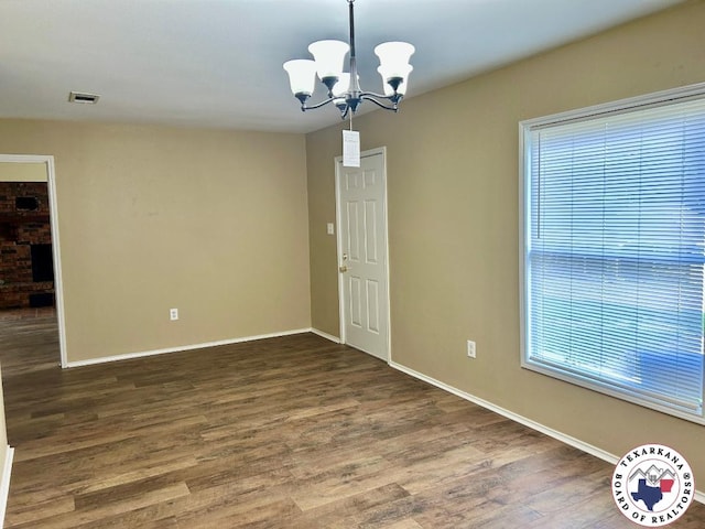 704 Florence St, Atlanta, TX 75551 - empty room featuring a chandelier, wood finished floors, and baseboards