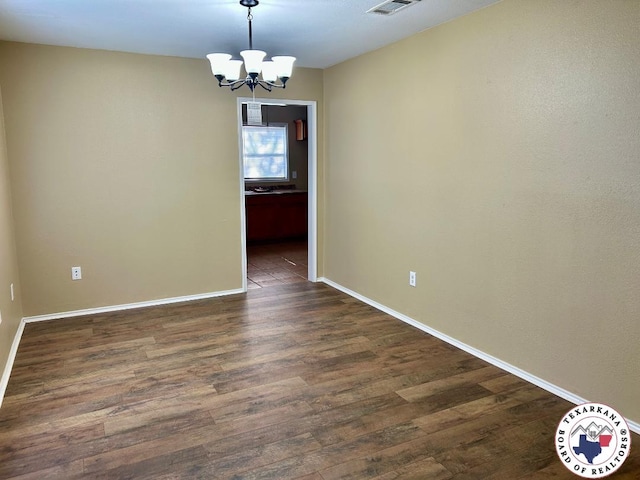 704 Florence St, Atlanta, TX 75551 - empty room featuring a chandelier, dark wood finished floors, and baseboards