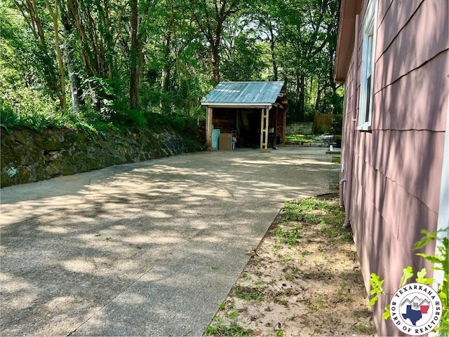 704 Florence St, Atlanta, TX 75551 - garage featuring concrete driveway and a storage shed