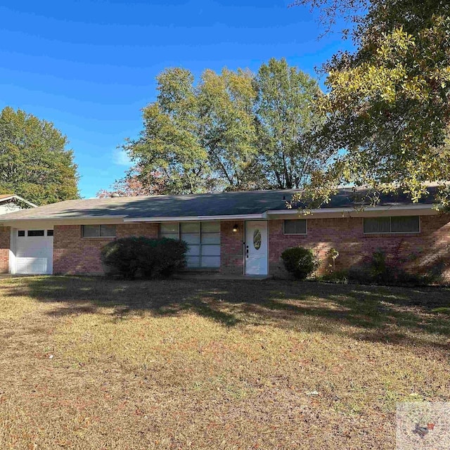 ranch-style home with a garage and a front lawn