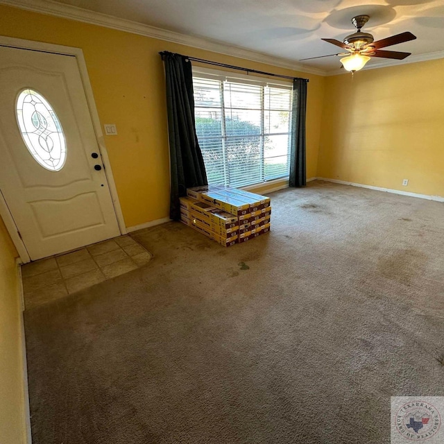 entryway with ceiling fan, ornamental molding, and carpet floors