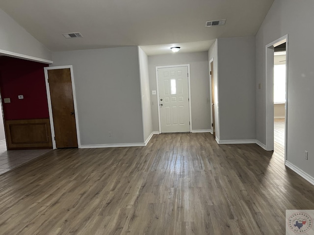 foyer with hardwood / wood-style floors and vaulted ceiling