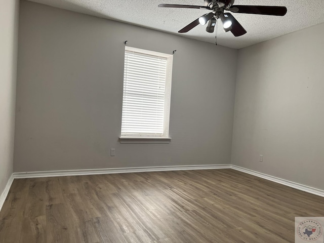 empty room featuring ceiling fan, a textured ceiling, and dark hardwood / wood-style floors