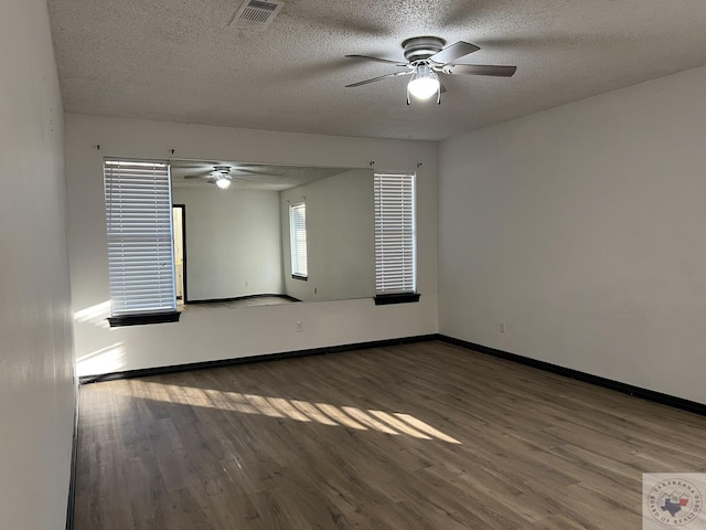 empty room featuring ceiling fan, hardwood / wood-style floors, and a textured ceiling