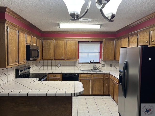 kitchen featuring appliances with stainless steel finishes, tile counters, decorative backsplash, sink, and kitchen peninsula