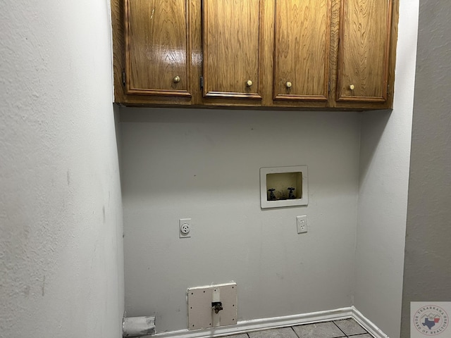 laundry area with electric dryer hookup, hookup for a washing machine, cabinets, and light tile patterned floors