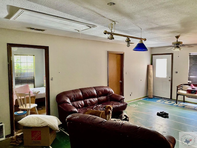 living room with ceiling fan and a textured ceiling