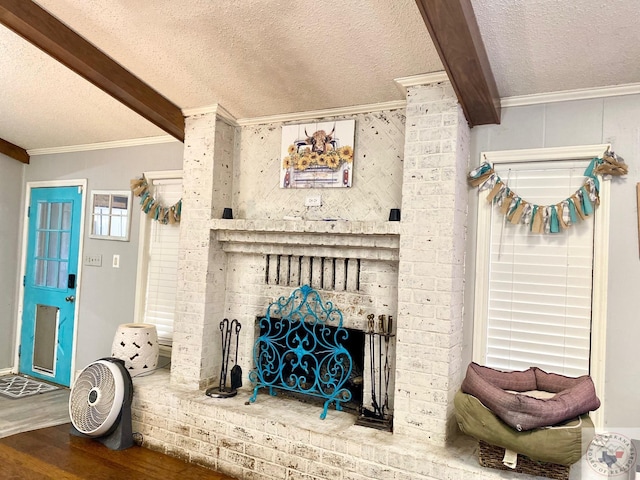 room details featuring a textured ceiling, a fireplace, wood-type flooring, ornamental molding, and beam ceiling