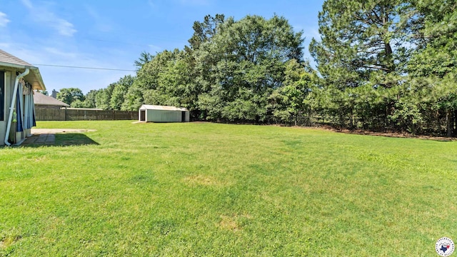 view of yard with an outbuilding, a fenced backyard, and a shed