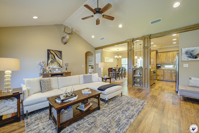 3428 Garrett Ln, Texarkana, TX 75503 - living room with arched walkways, ceiling fan, light wood finished floors, a chandelier, and vaulted ceiling