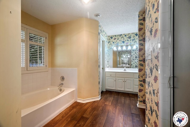 6102 Deerfield Dr, Texarkana, TX 75503 - full bathroom with a textured ceiling, wood finished floors, baseboards, vanity, and a garden tub