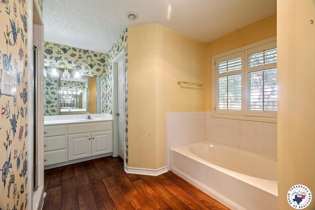 6102 Deerfield Dr, Texarkana, TX 75503 - full bath featuring wallpapered walls, baseboards, wood finished floors, a textured ceiling, and a bath