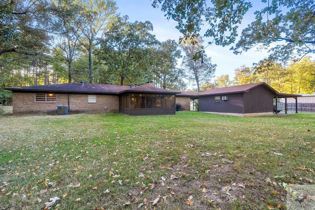 back of house with a sunroom and a lawn