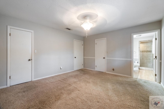 spare room with a textured ceiling and carpet flooring