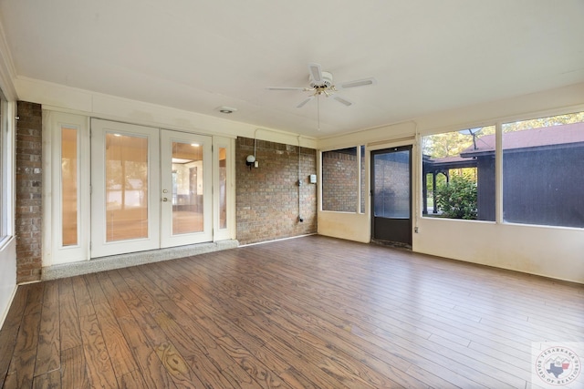 unfurnished sunroom with ceiling fan and french doors