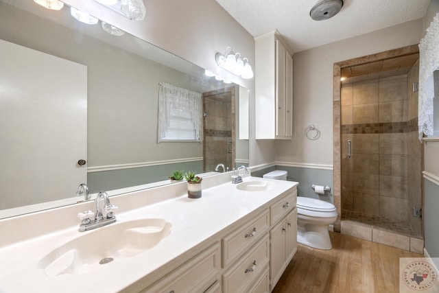 bathroom featuring toilet, walk in shower, a textured ceiling, and wood-type flooring