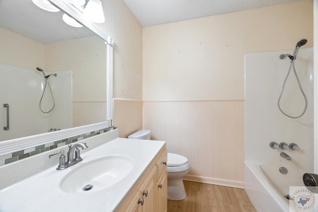 full bathroom featuring hardwood / wood-style flooring, toilet, vanity, and bathing tub / shower combination