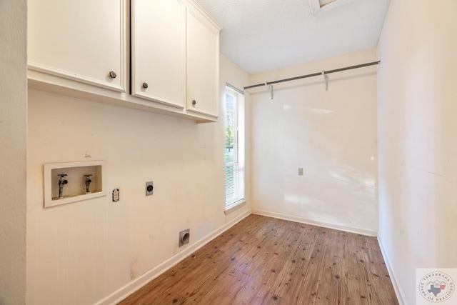 washroom featuring light wood-type flooring, hookup for a washing machine, hookup for an electric dryer, and cabinets