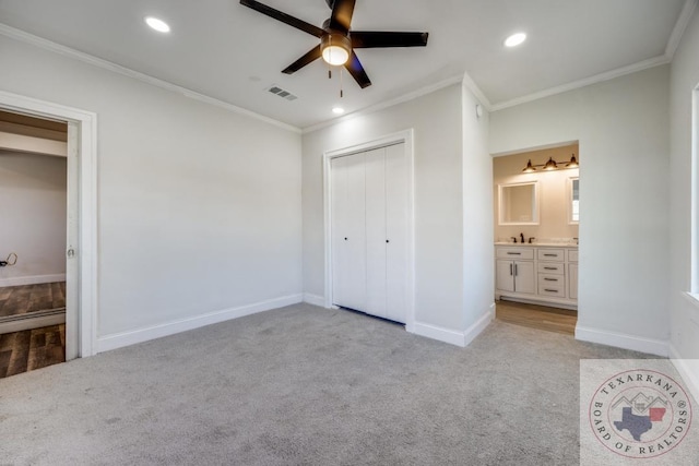908 W Washington St, Clarksville, TX 75426 - unfurnished bedroom featuring a closet, crown molding, and light colored carpet
