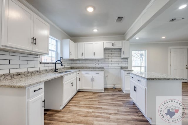 908 W Washington St, Clarksville, TX 75426 - kitchen with sink, light stone countertops, and white cabinets
