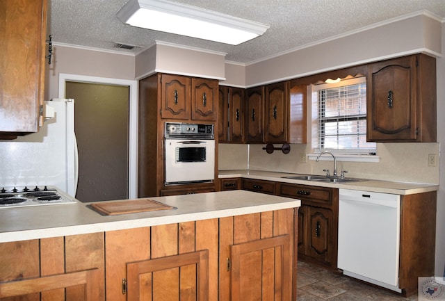 kitchen with sink, white appliances, kitchen peninsula, and a textured ceiling