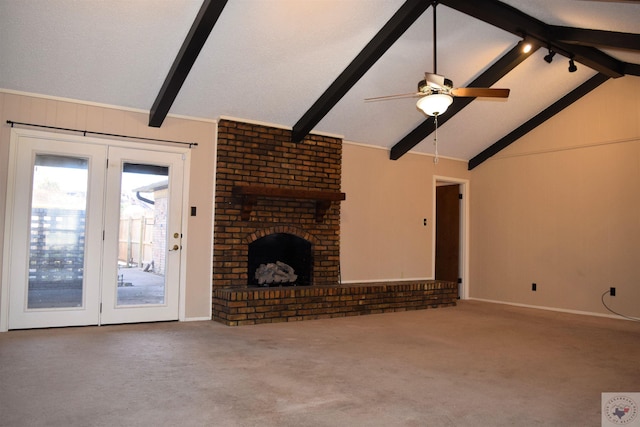 unfurnished living room with a brick fireplace, lofted ceiling with beams, ceiling fan, and carpet flooring