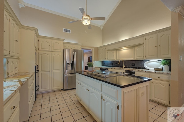 kitchen with light tile patterned floors, high vaulted ceiling, a center island, and stainless steel fridge