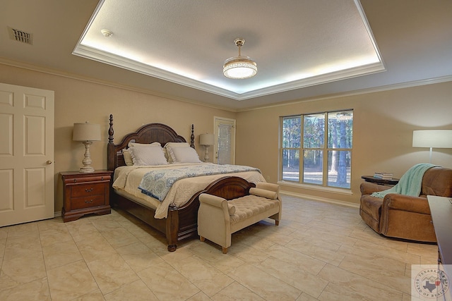 bedroom with ornamental molding and a raised ceiling