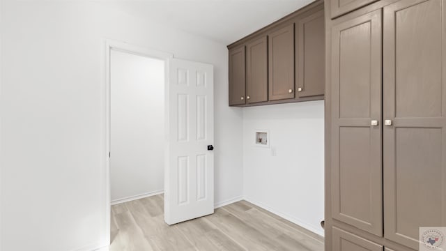 washroom with hookup for a washing machine, light wood-type flooring, cabinet space, and baseboards