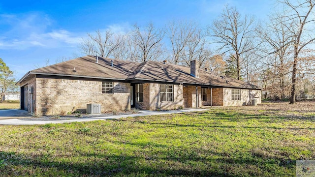 ranch-style home featuring brick siding, a chimney, central AC, a garage, and a front lawn