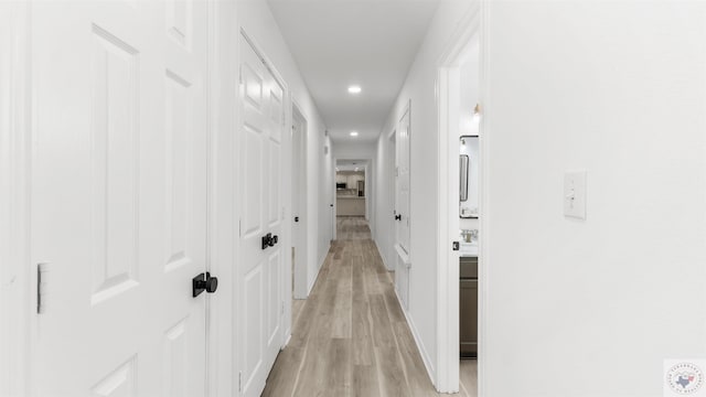 hallway with light wood-style flooring and recessed lighting