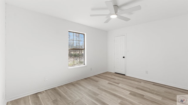 spare room featuring baseboards, a ceiling fan, and light wood-style floors