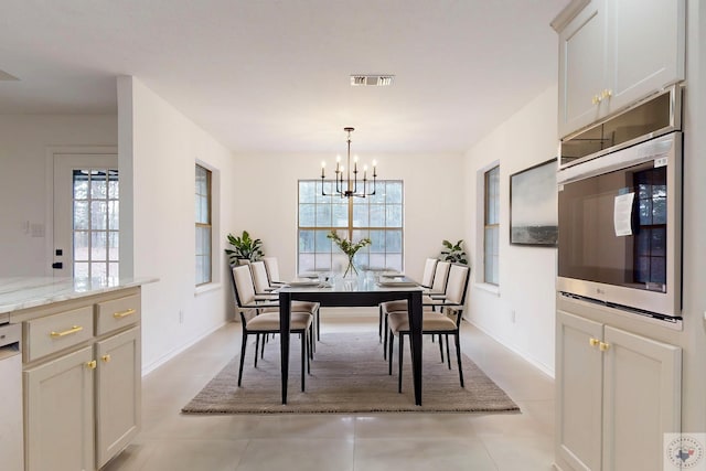 dining space with light tile patterned floors, baseboards, visible vents, and a notable chandelier