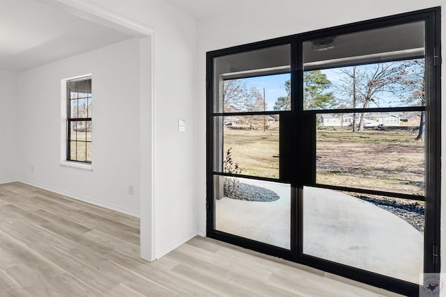 doorway to outside with light wood-style floors and baseboards