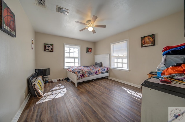 bedroom featuring ceiling fan, dark hardwood / wood-style flooring, and multiple windows