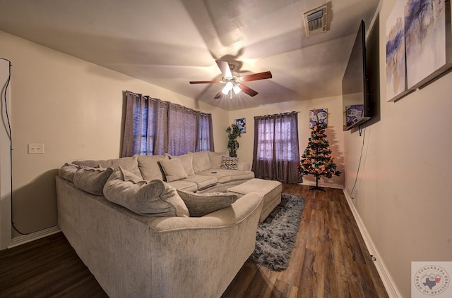 living room featuring ceiling fan and dark hardwood / wood-style flooring