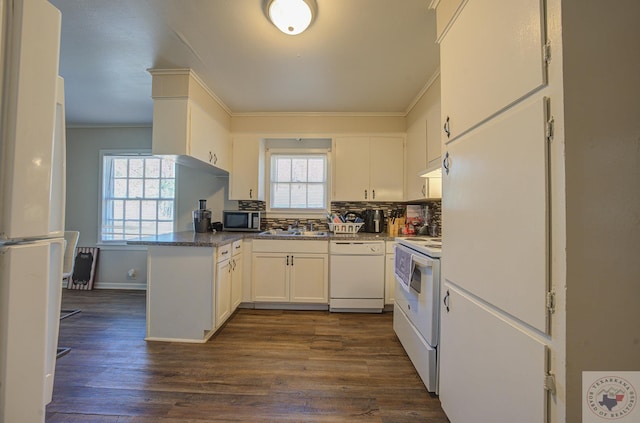 kitchen featuring white appliances, white cabinets, sink, dark hardwood / wood-style floors, and kitchen peninsula