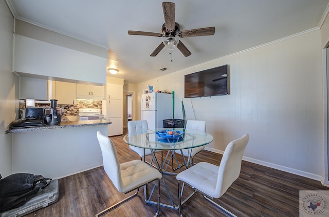 dining area featuring dark wood-type flooring, ceiling fan, and ornamental molding