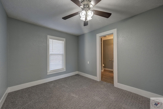 carpeted empty room with ceiling fan and a textured ceiling