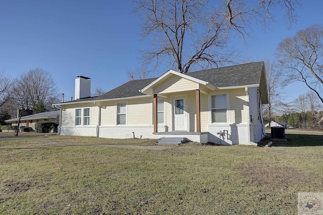 view of front of home with central air condition unit and a front yard