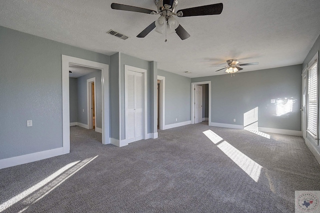 interior space with ceiling fan, carpet, and a textured ceiling